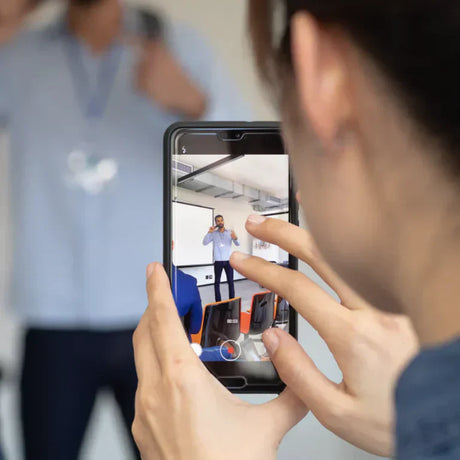 Persona registra un oratore con uno smartphone in interni