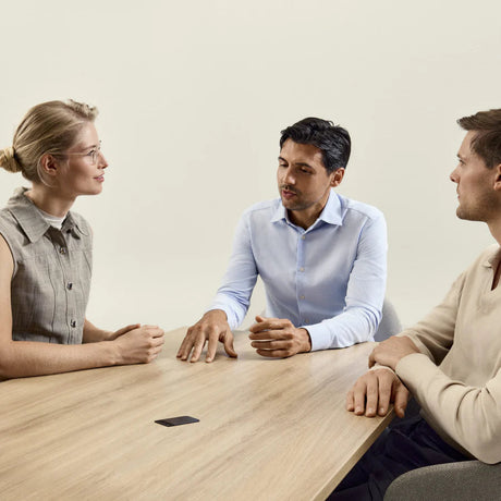Tre persone che conversano a un tavolo