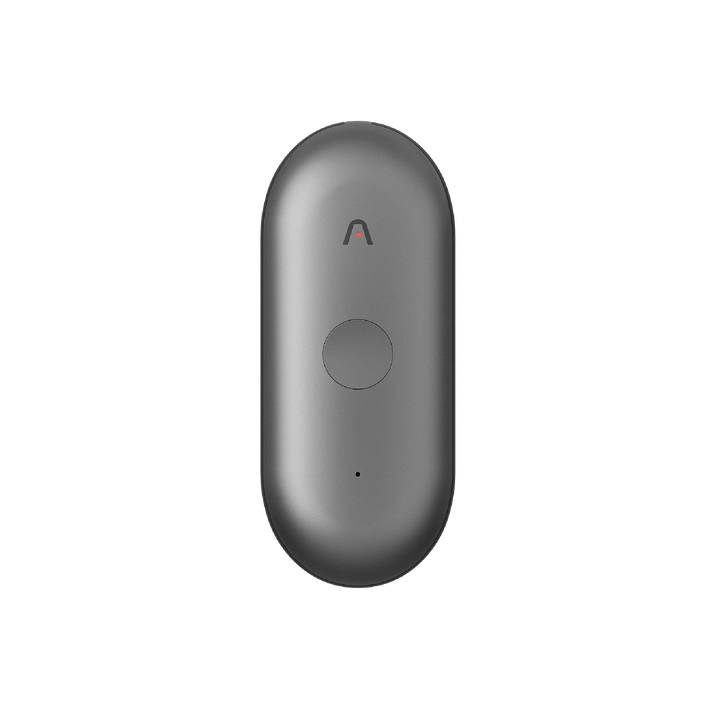 Un registratore vocale AI Plaud NotePin S grigio, con un logo '∧' e un pulsante rotondo, è mostrato verticalmente su sfondo bianco.